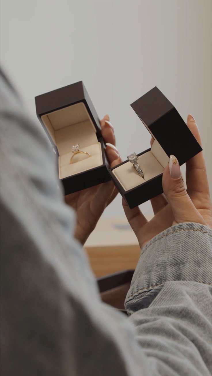 Two Aura engagement rings in presentation boxes