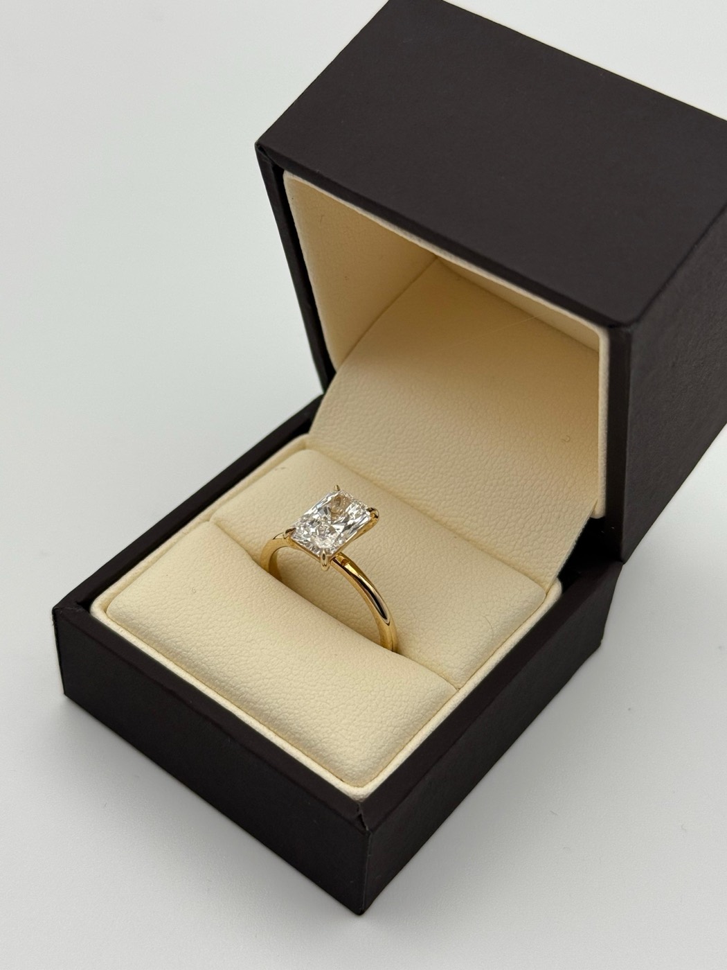 Yellow gold radiant cut solitaire engagement ring in a presentation box